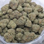 Macro close-up of Tropicana Cherry strain Nelson Farm Craft AAAA cannabis flower with frosty trichomes